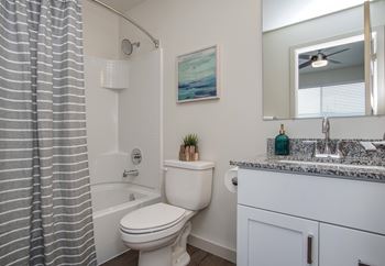 A bathroom with a toilet, sink, and shower curtain.
